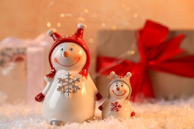 Photo of Funny snowman figures on artificial snow against blurred background