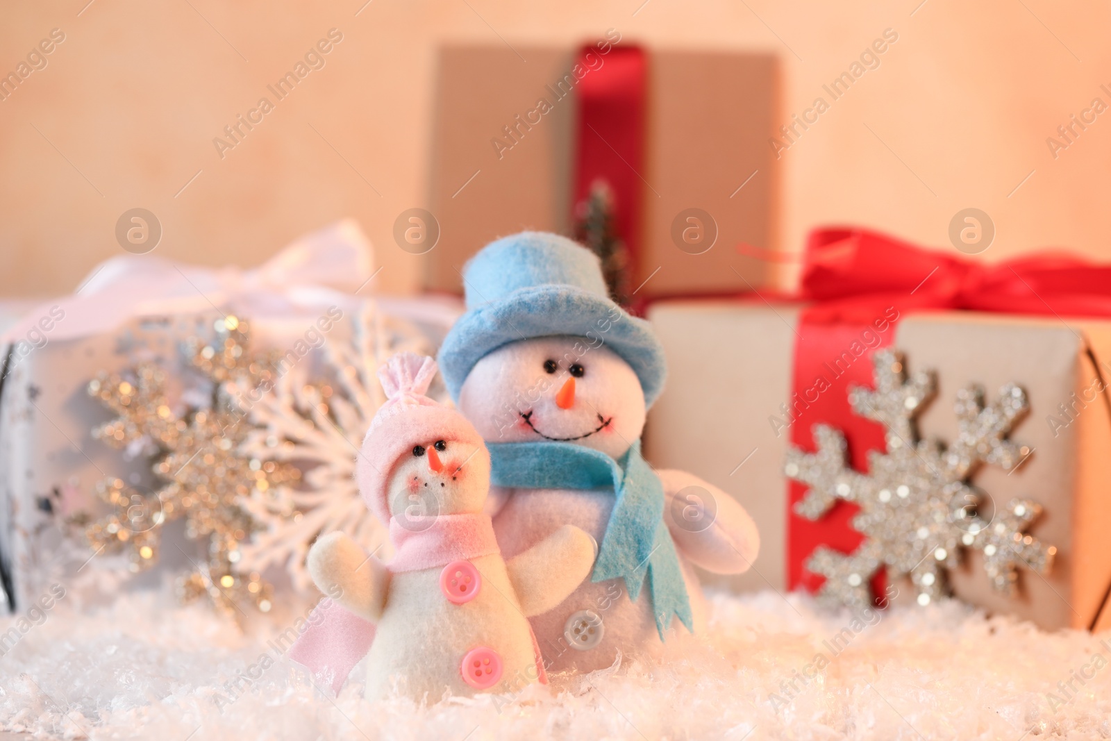 Photo of Funny snowman figures and gifts on artificial snow