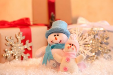 Photo of Funny snowman figures and gifts on artificial snow