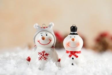 Photo of Funny snowman figures on artificial snow against blurred background