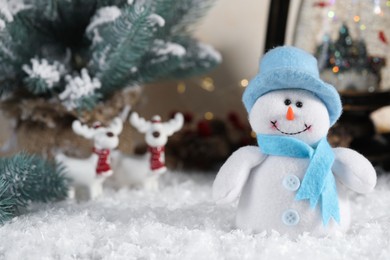 Photo of Funny snowman figure and Christmas decor on artificial snow