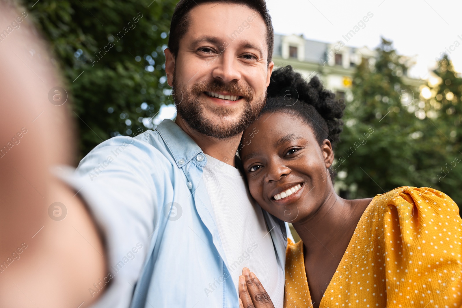 Photo of International relationships. Lovely couple taking selfie outdoors