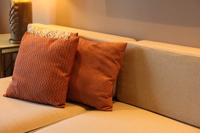 Comfortable sofa with cushions in room, closeup