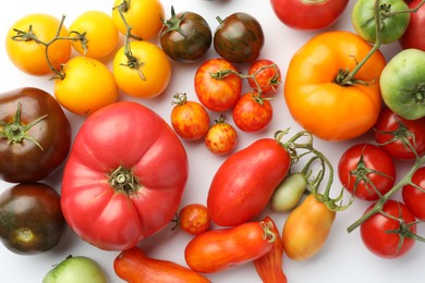 Photo of Different ripe tomatoes on white background, flat lay