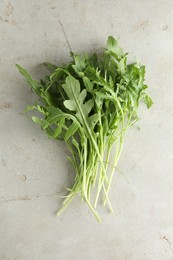 Photo of Many fresh arugula leaves on grey textured table, top view