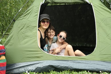 Mother and her kids resting in camping tent outdoors