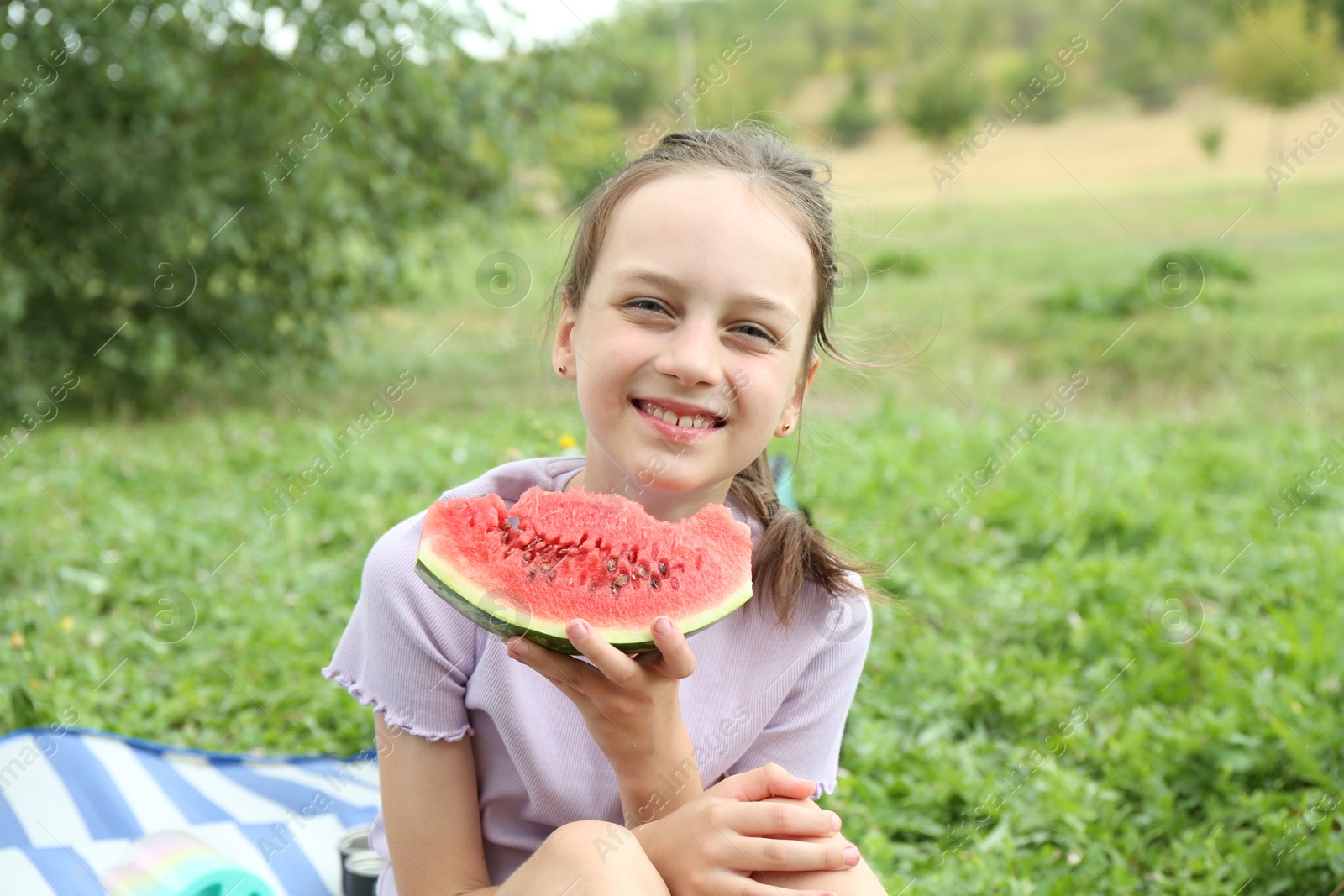 Photo of Girl with slice of fresh watermelon outdoors