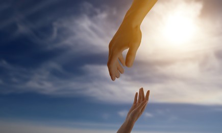 Image of God's help and support. Human reaching for hand from heaven