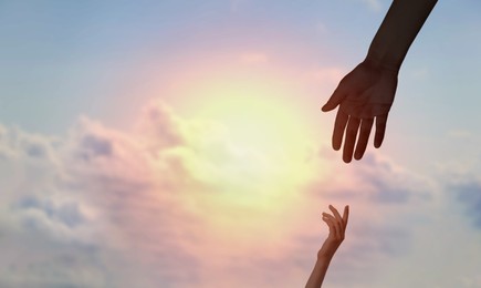 Image of God's help and support. Human reaching for hand from heaven