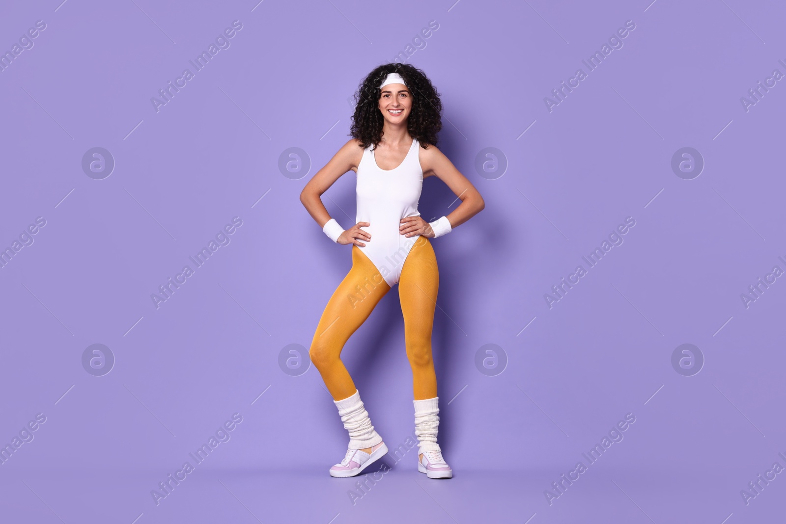 Photo of Happy woman in sportswear on purple background