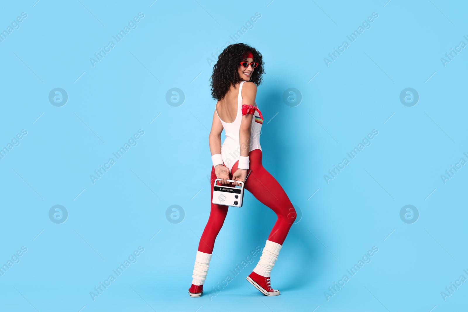 Photo of Aerobics. Happy woman with radio receiver on light blue background