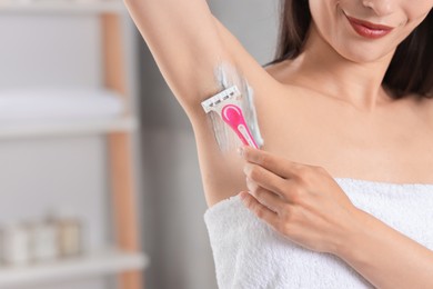 Photo of Woman shaving armpit indoors, closeup. Space for text