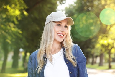 Photo of Portrait of smiling woman in baseball cap outdoors