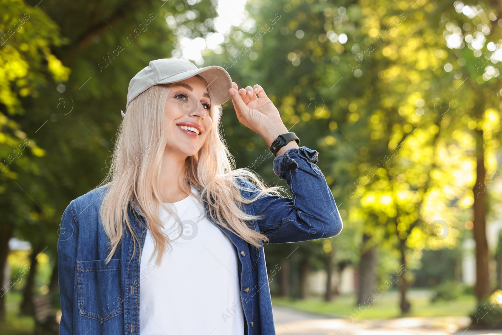 Photo of Portrait of smiling woman in baseball cap outdoors