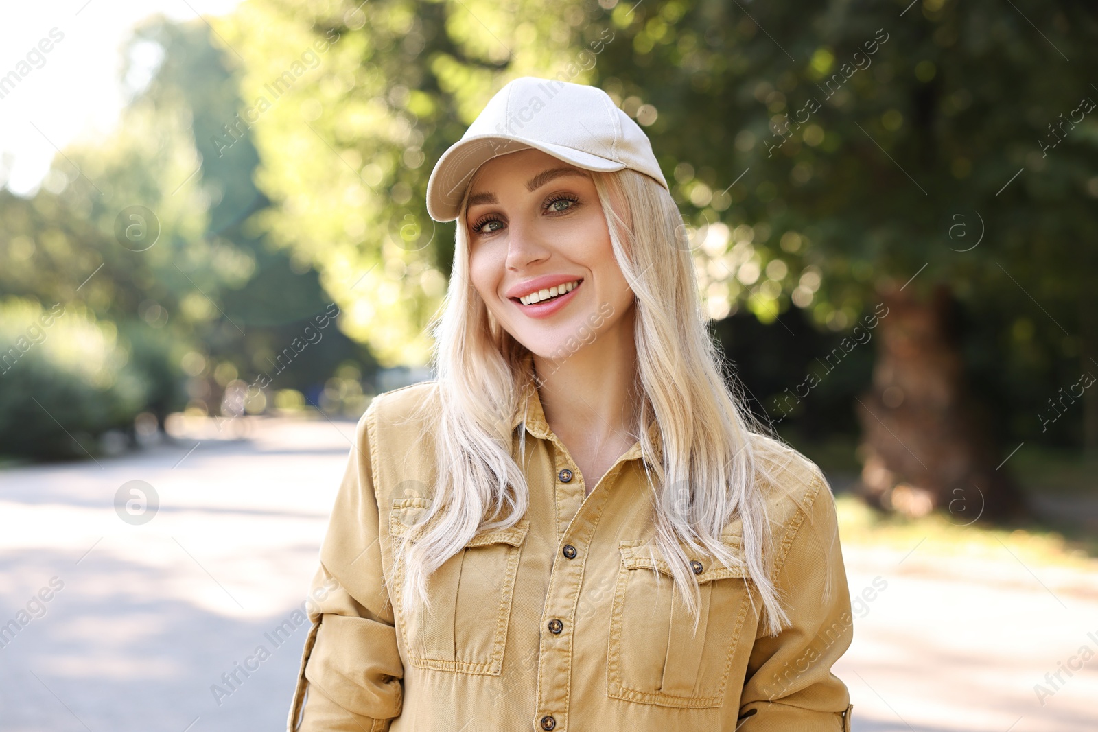 Photo of Portrait of smiling woman in baseball cap outdoors