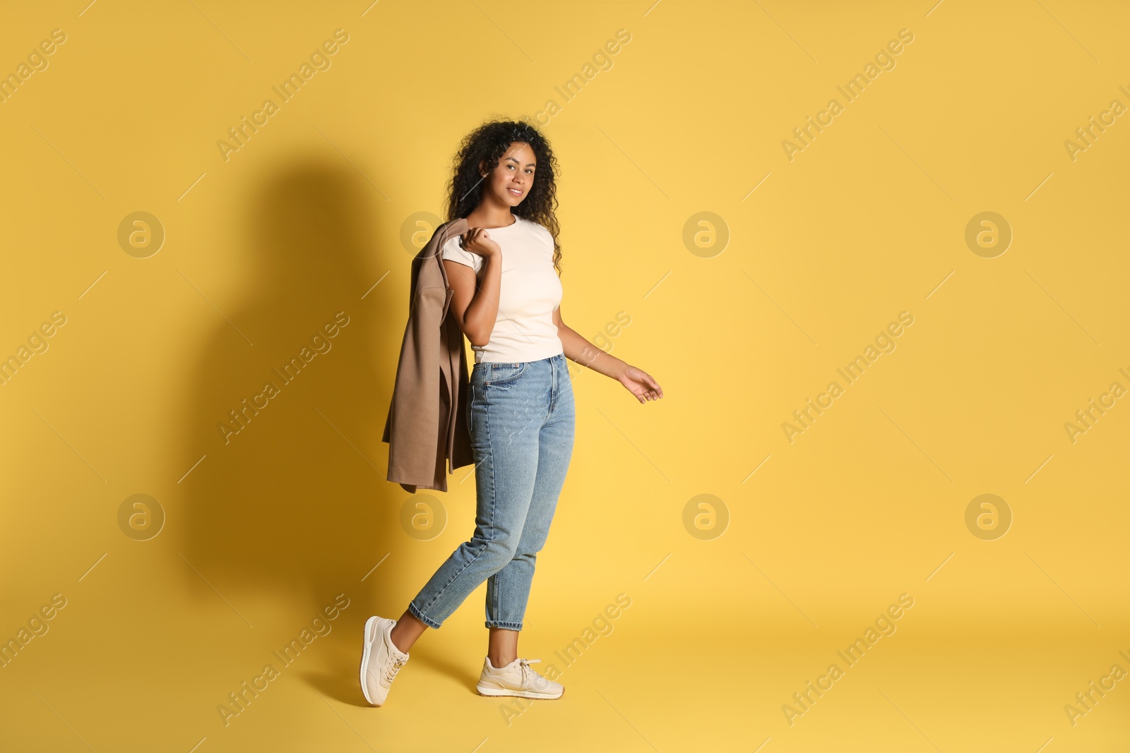 Photo of Beautiful woman with stylish jacket on yellow background