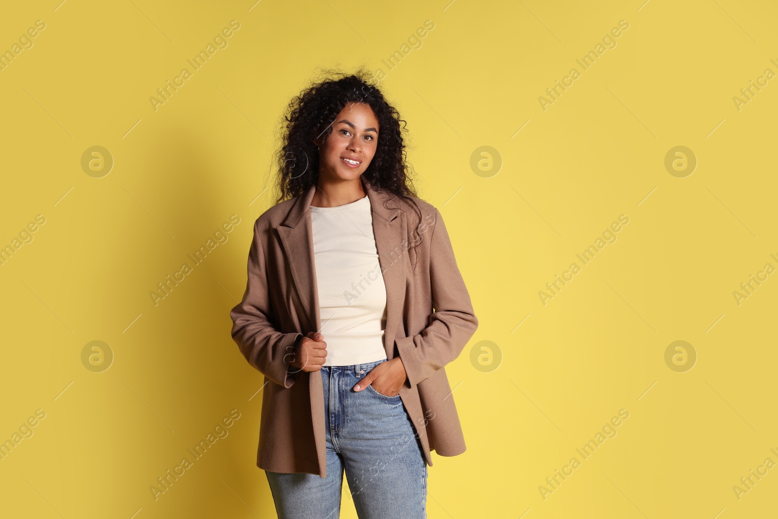 Photo of Beautiful woman in stylish jacket on yellow background