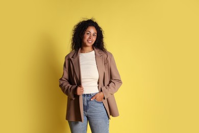 Photo of Beautiful woman in stylish jacket on yellow background