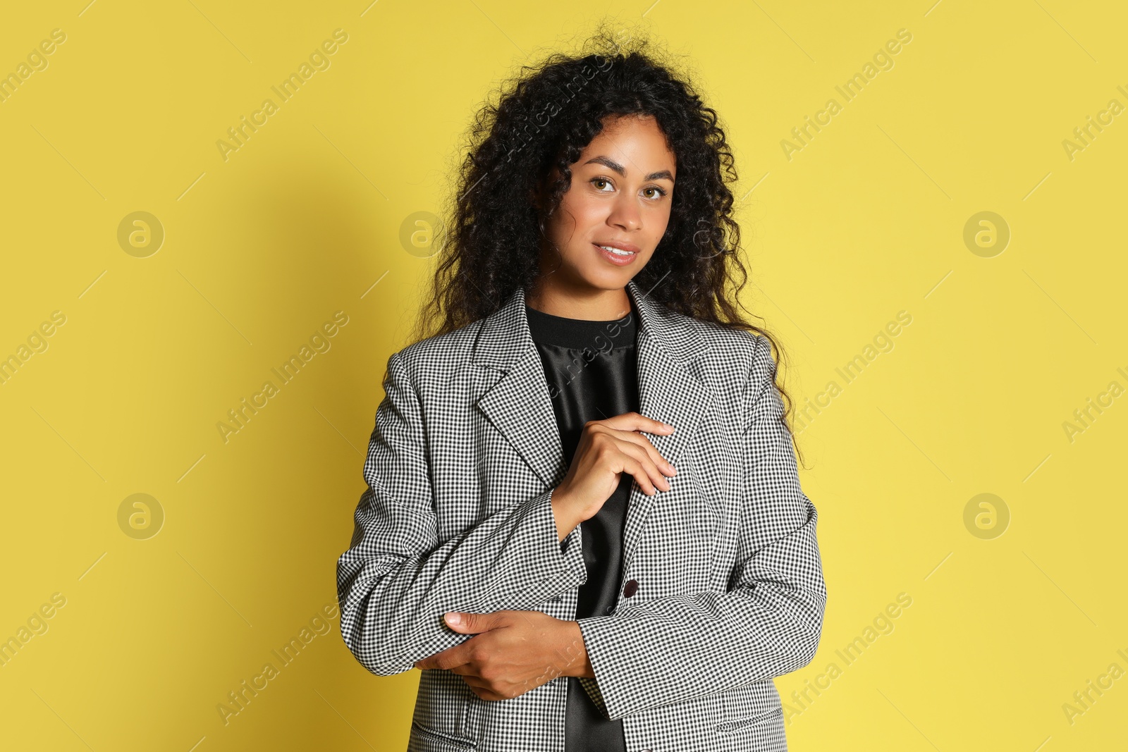 Photo of Beautiful woman in stylish jacket on yellow background