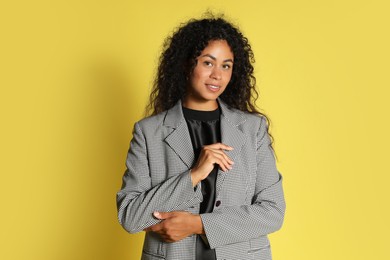 Photo of Beautiful woman in stylish jacket on yellow background