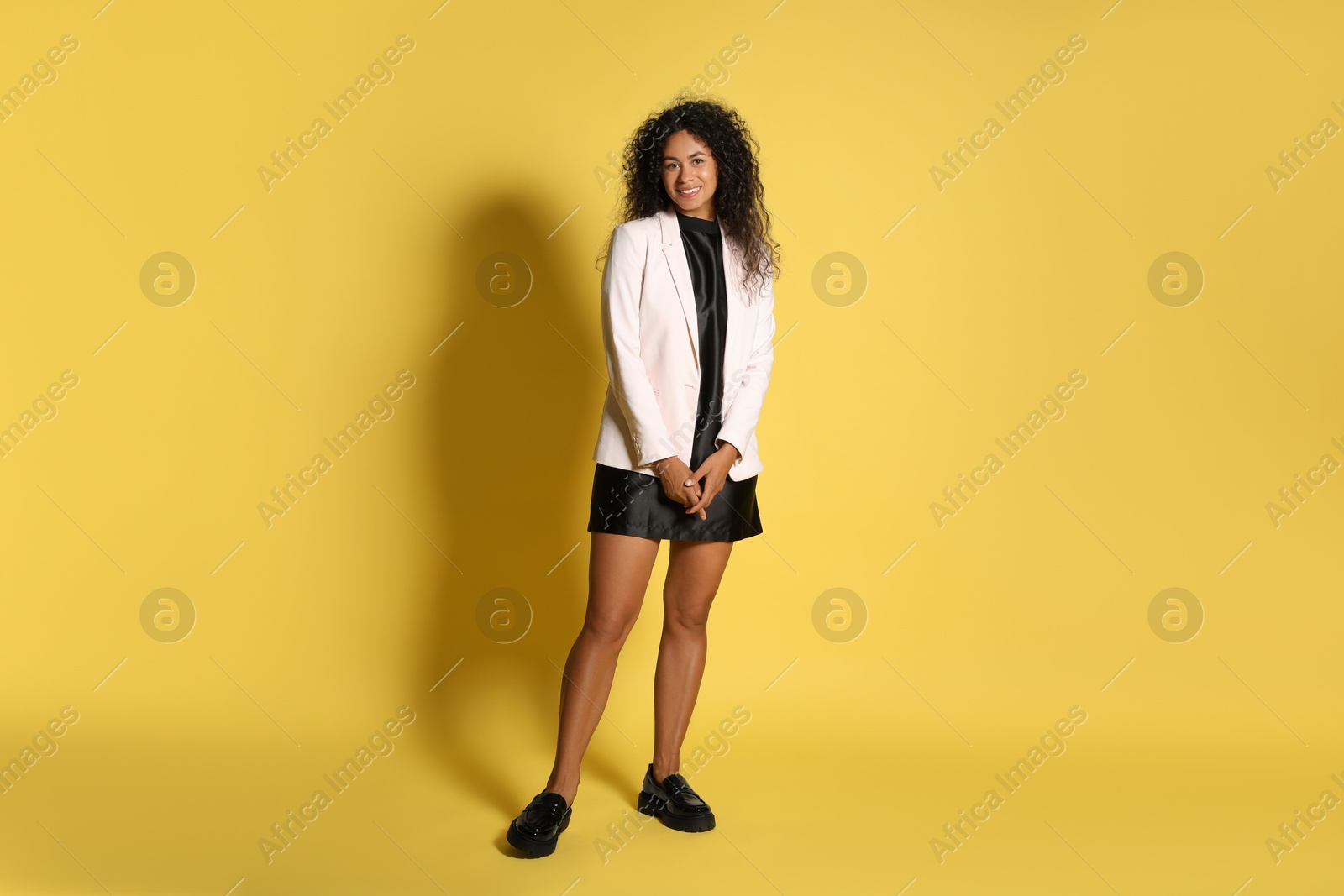 Photo of Beautiful woman in stylish jacket on yellow background