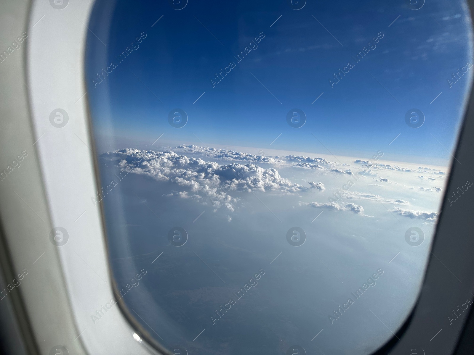 Photo of Beautiful blue sky with fluffy clouds, view from plane window