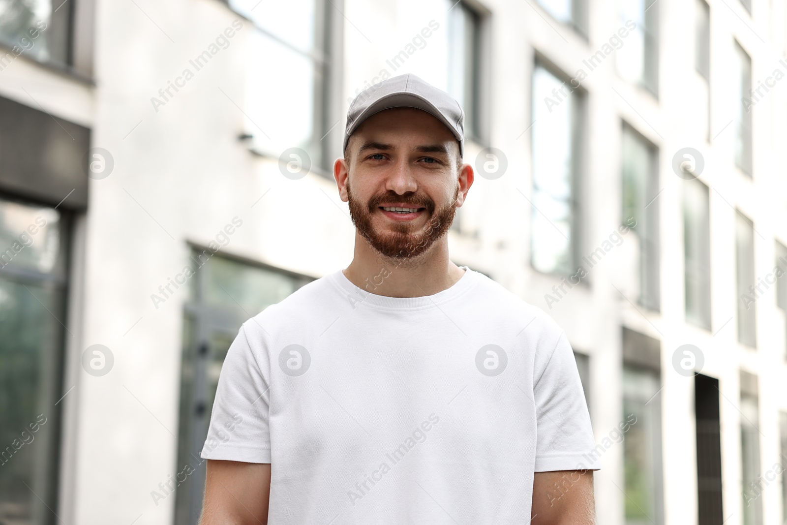 Photo of Portrait of smiling man in baseball cap outdoors