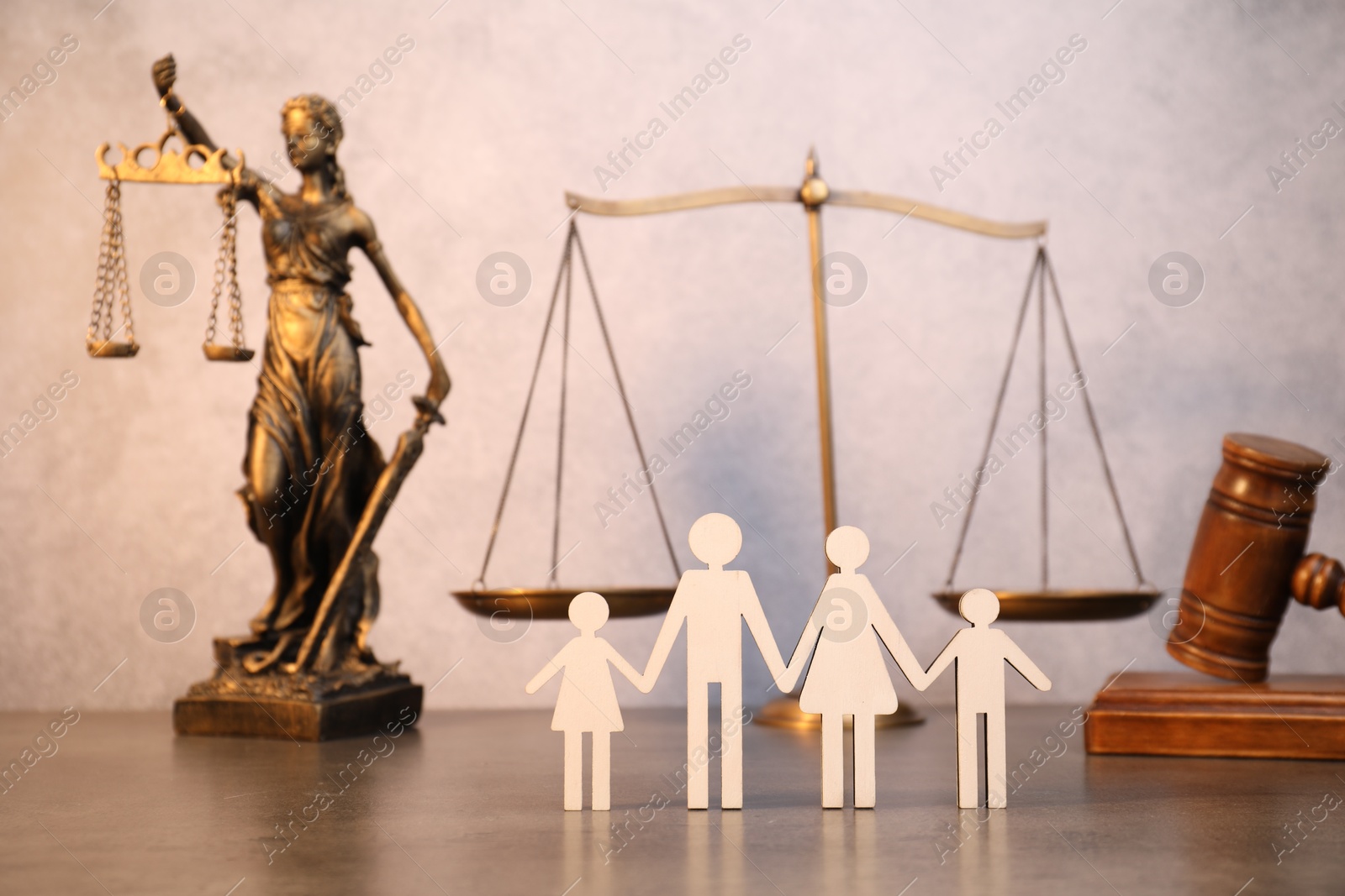 Photo of Alimony. Figures of family, scales, wooden gavel and statue of Lady Justice on table