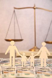 Alimony. Figures of family and dollar banknotes on table, closeup