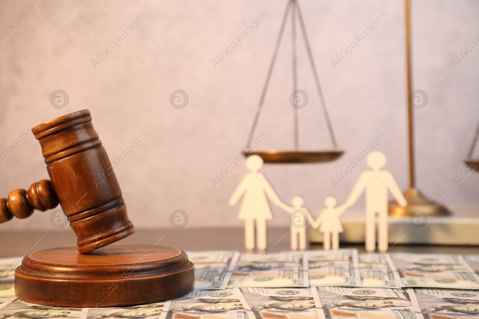 Photo of Alimony. Wooden gavel and dollar banknotes on table