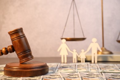 Alimony. Wooden gavel and dollar banknotes on table