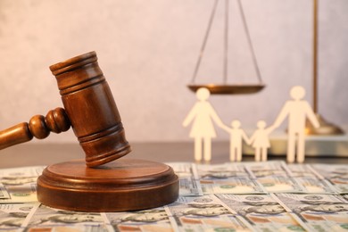 Alimony. Wooden gavel and dollar banknotes on table