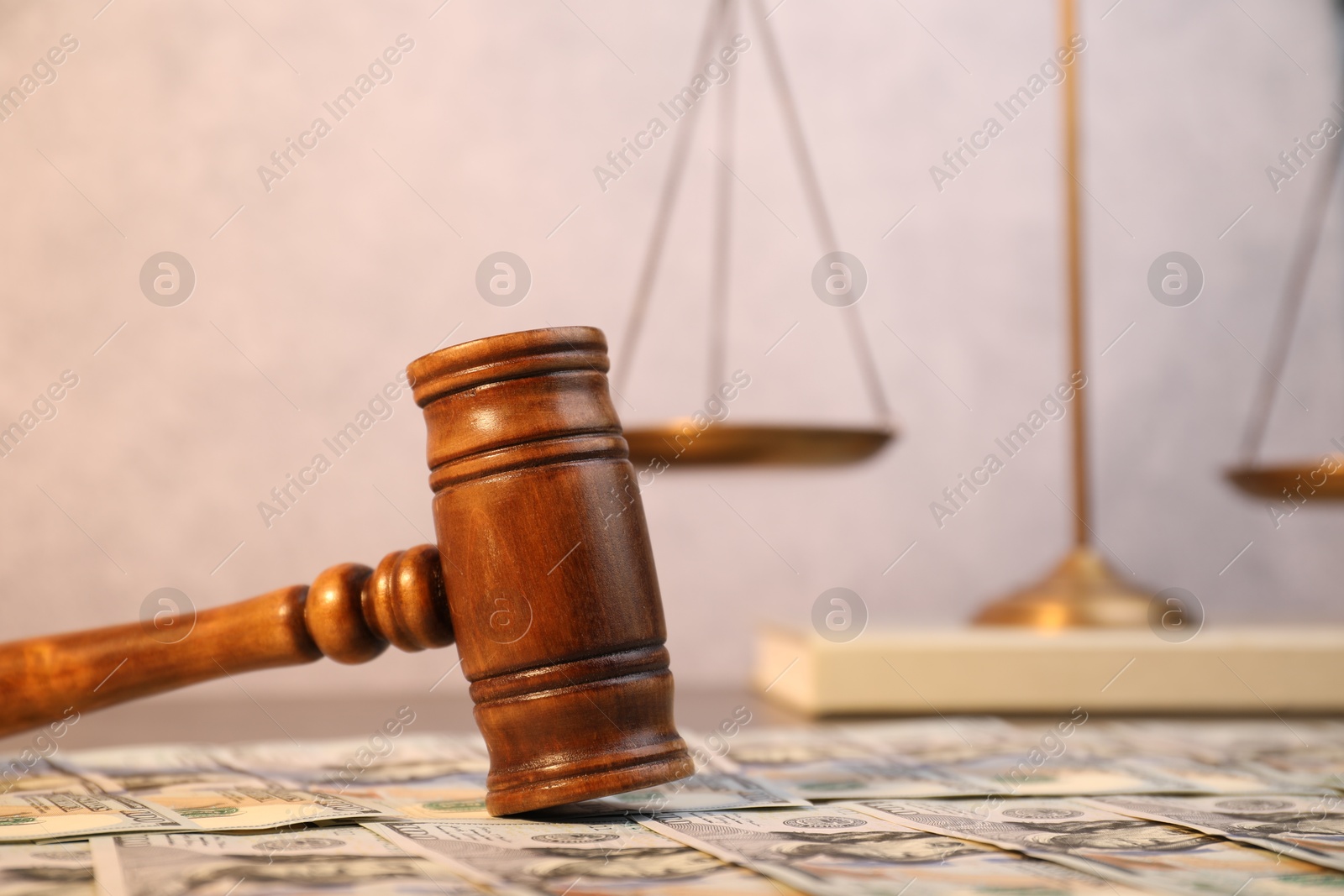 Photo of Alimony. Wooden gavel and dollar banknotes on table, closeup