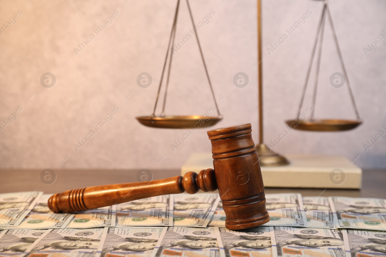 Photo of Alimony. Wooden gavel and dollar banknotes on table