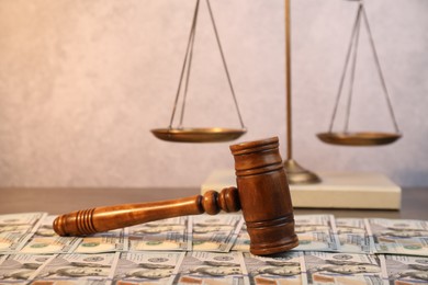 Alimony. Wooden gavel and dollar banknotes on table