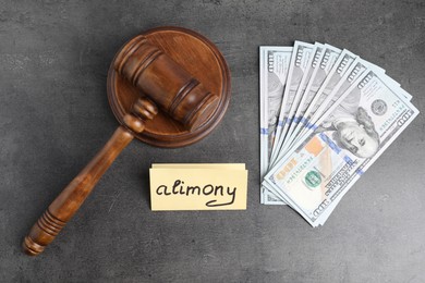 Card with word Alimony, dollar banknotes and wooden gavel on grey table, flat lay