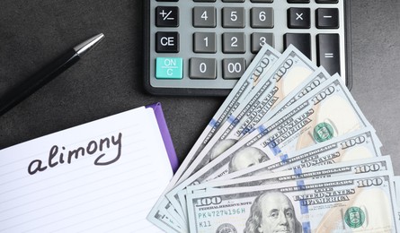 Photo of Notebook with word Alimony, dollar banknotes, calculator and pen on grey table, flat lay