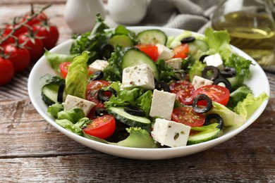 Photo of Delicious salad with feta cheese on wooden table, closeup