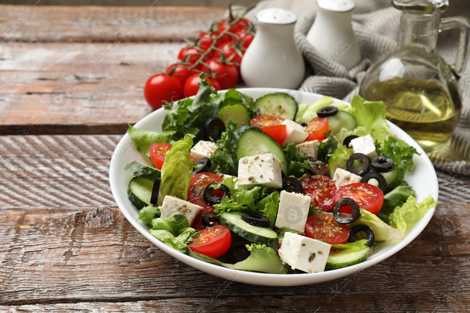 Photo of Delicious salad with feta cheese on wooden table, closeup