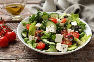 Delicious salad with feta cheese on wooden table, closeup