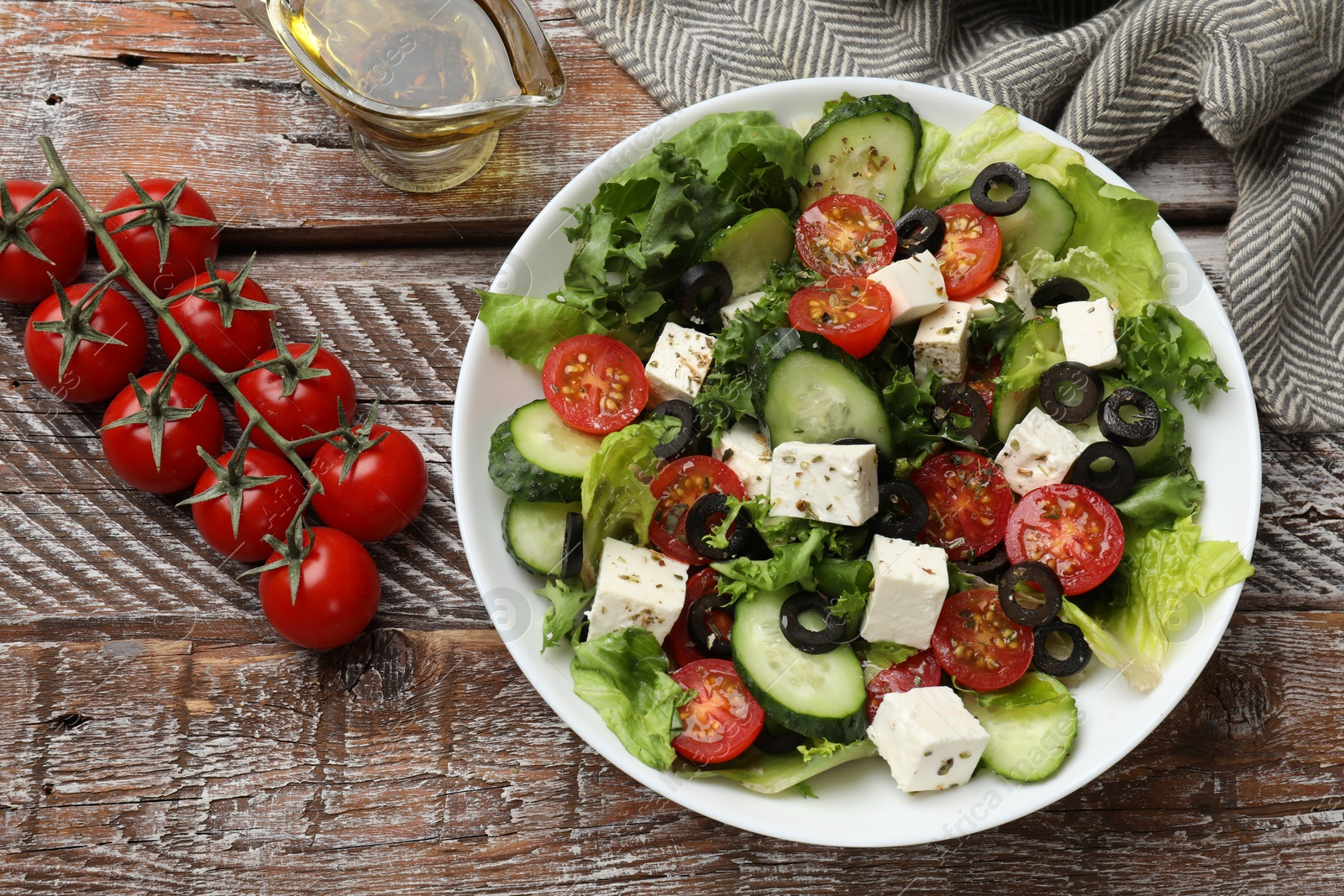 Photo of Delicious salad with feta cheese on wooden table, flat lay