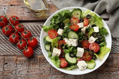 Photo of Delicious salad with feta cheese on wooden table, flat lay