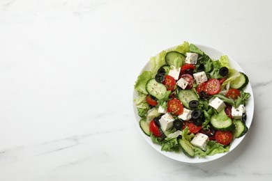 Delicious salad with feta cheese on white marble table, top view. Space for text