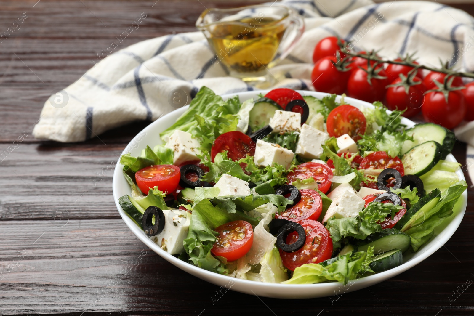 Photo of Delicious salad with feta cheese on wooden table, closeup