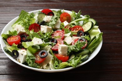 Photo of Delicious salad with feta cheese on wooden table, closeup