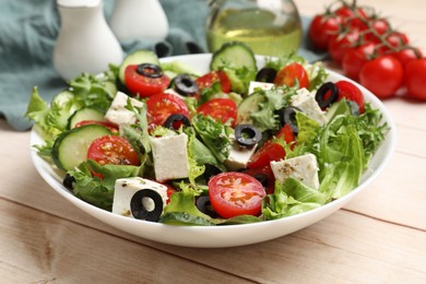 Photo of Delicious salad with feta cheese on white wooden table, closeup