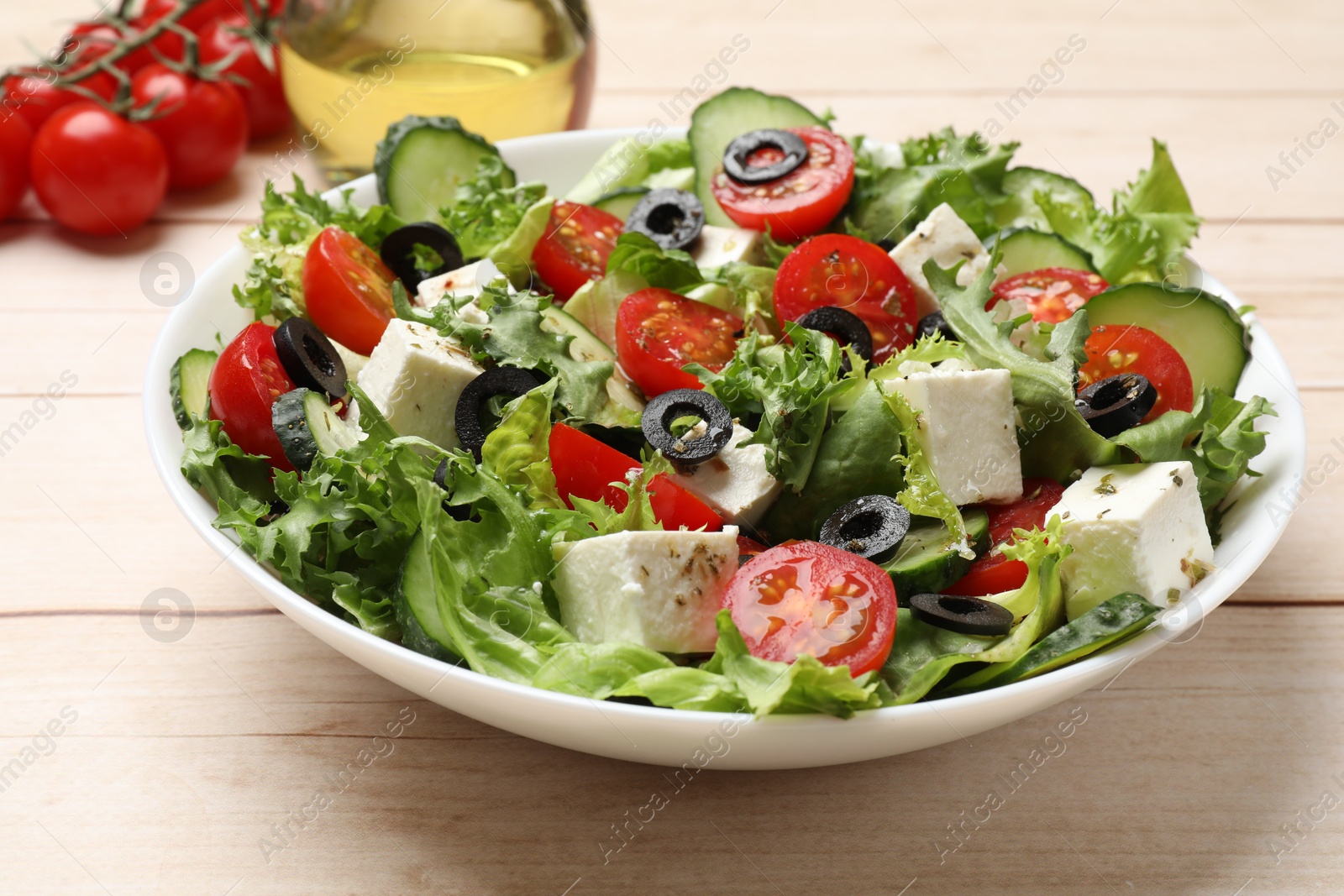 Photo of Delicious salad with feta cheese on white wooden table, closeup