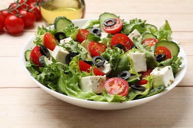 Photo of Delicious salad with feta cheese on white wooden table, closeup