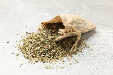 Sack with dried oregano on grey table, closeup