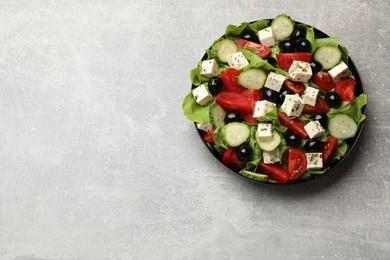 Photo of Delicious salad with feta cheese on grey table, top view. Space for text